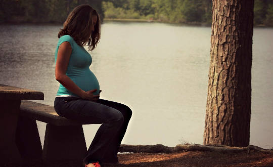 Essential Tips for the Journey: Release Fear and Take Care of Yourself pregnant woman sitting with her hands on her belly