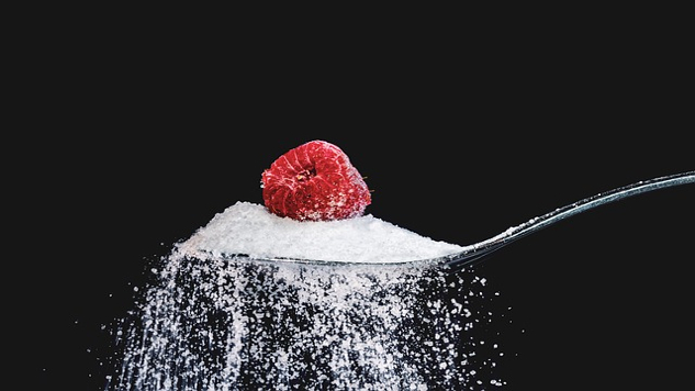 Sugar—Not So Sweet? a raspberry sitting on top of a teaspoon of sugar