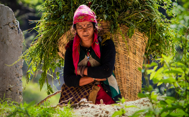 a young woman sitting on the ground in a rural setting