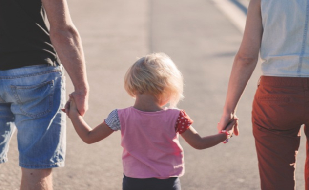 Co-Parenting Rules: How To Be a Good Parent After Divorce a child holding hands with her parents - one on each side