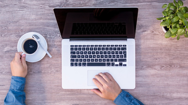a man at his laptop with a cup of coffee
